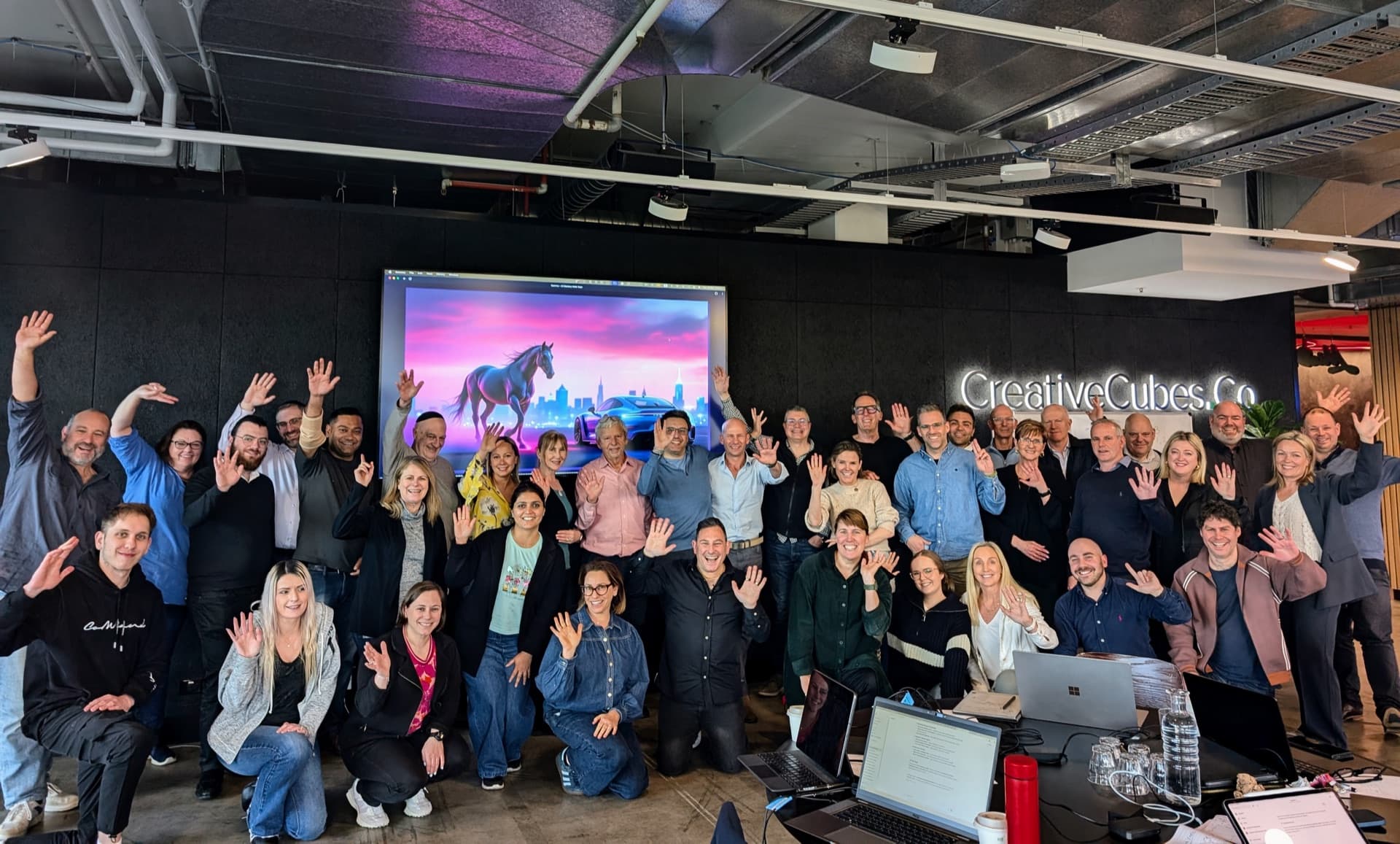 An AI Mastery workshop group in Melbourne with hands raised at the end of the day